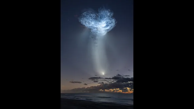 10月13日のSpaceX CRS-35打ち上げ。海と夜明け前の空の上に、太陽光を受けた排気の大きなクラゲ状の光が広がる。